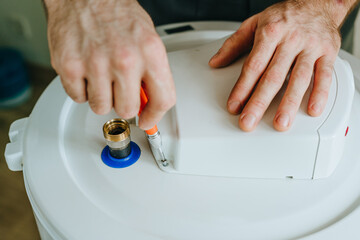 Technician's hands performing assembly of a water boiler