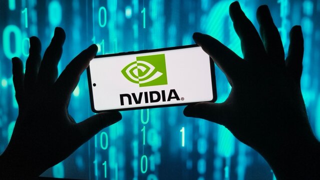 Hands hold smartphone displaying nvidia logo against binary code