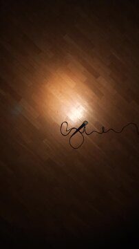 Vertical video comedian dropping microphone on wooden stage floor after a performance, capturing the moment of confidence and finality in stand up comedy culture and success