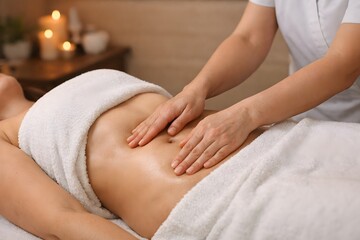 Close up of manual lymphatic drainage on female abdomen for body detox and swelling reduction during wellness therapy