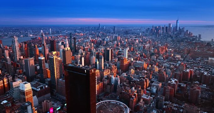 Descend along the tower of One Penn Plaza in New York, USA. Vast perspective eon the metropolis at sunset time.