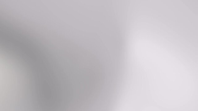 Abstract blurred background with soft gray tones and subtle gradient effects, viewed from a straight-on perspective as a blurred image