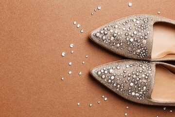 Obraz premium Elegant footwear with sparkling embellishments displayed on a warm brown surface