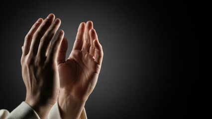 Praying hands gesture, open palms reaching upwards, illuminated on dark background, symbolizing spiritual devotion. Hands convey faith, hope, reverence during prayer.