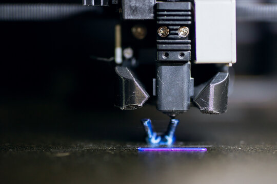 Detailed shot showcasing filament extrusion onto heated surface under curing illumination