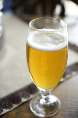 Refreshing glass of beer on a wooden table at a restaurant