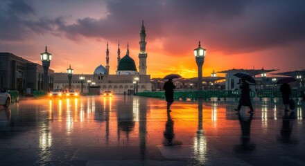Naklejka premium People walk with umbrellas in front of a mosque during a rainy sunset
