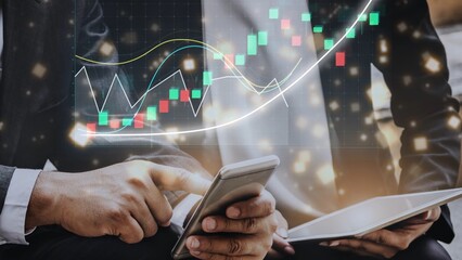A business professional examines stock market trends using a smartphone and tablet in a modern office. Graphical data overlays enhance the financial analysis process. Copula