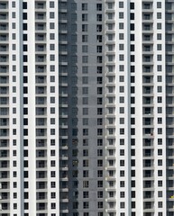 Fototapeta premium Vertical Patterns of Modern Highrise Residential Building Facade in Urban Landscape