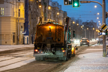 Śnieżny pług. Pług śnieżny zgarnia śnieg z ulicy w mieście Zima © FotoDax
