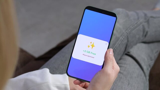 Person frees up 2GB of storage using a mobile cleaning tool. Features clear interaction, fast boosting process, and successful result. Great for mobile productivity, storage management, and consumer