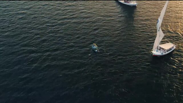Aerial view of traditional Egyptian Felucca sailing on the Nile River at sunset, Aswan, Egypt