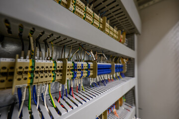 A terminal block with wires on a DIN rail in an electrical cabinet.