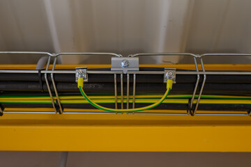 A bonding/grounding jumper on a metal cable tray with cables.