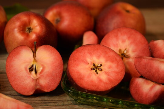 Baya Marisa apples on wooden background, red pulp and skin apples closeup.