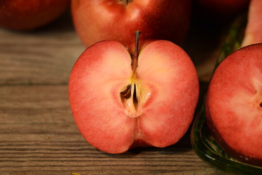 Baya Marisa apples on wooden background, red pulp and skin apples closeup.