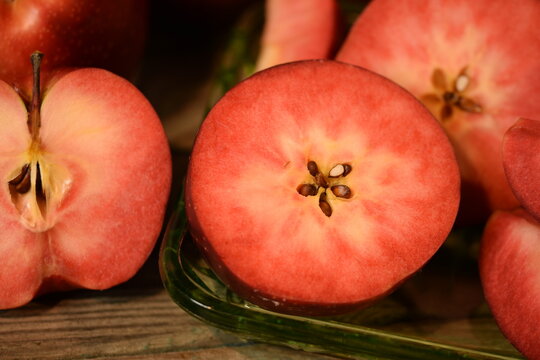 Baya Marisa apples on wooden background, red pulp and skin apples closeup.