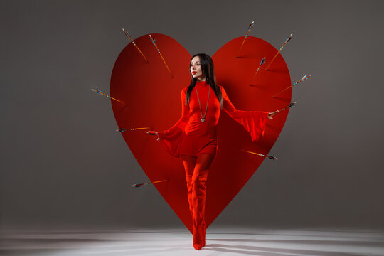 Valentine banner woman in red dress with heart pierced by cupid arrows