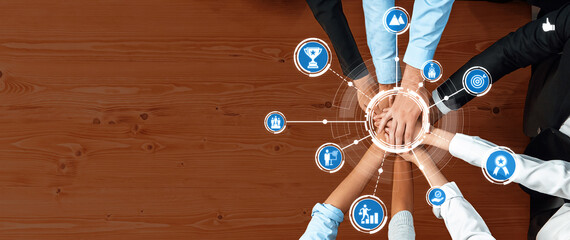 A top view of diverse hands coming together on a table, symbolizing teamwork, collaboration, and...