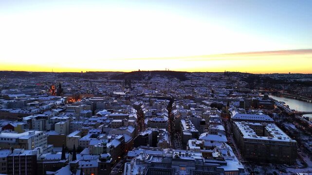 Drone aerial panorama of a city at sunset, showing expansive urban rooftops, evening glow, and wide horizon under fading daylight in a cinematic atmospheric view.