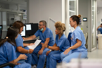 Diverse medical team collaborating on patient data in hospital