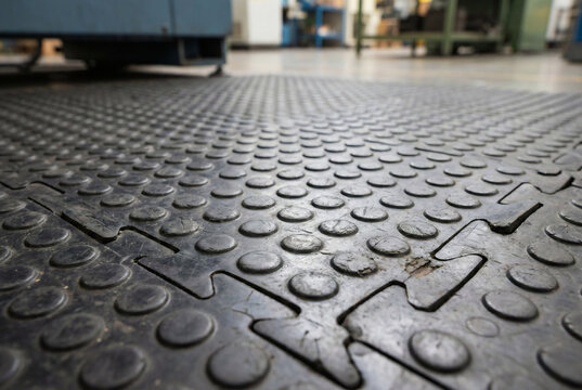 Black industrial rubber safety flooring mat texture close up in factory