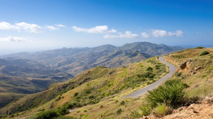 Scenic winding road through hills with mountains in the distance