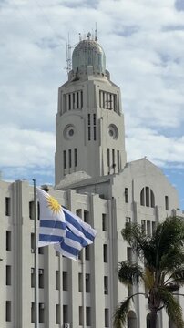 Vertical Video - Uruguay Flag Blowing at The Port of Montevideo South American. Rio de la Plata, Historic Customs Building Aduana. Landmark Tourism