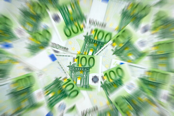 Heap of 100 euro cash banknotes with zoom blur effect. Financial concept shot with European money. 