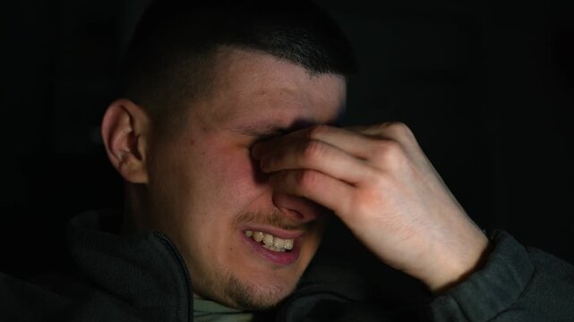 A man rubs his eyes with his hands.
Something got into the guy's eye.
Eye discomfort.
Sore eyeball.