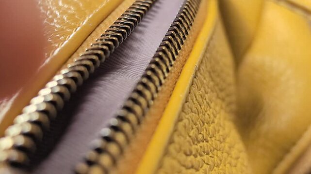 A man interacts with a bright yellow bag, opening it carefully to reveal its contents. The zipper glides smoothly as he demonstrates its practicality and style under warm sunlight.