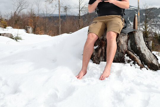 a man wanders barefoot in the snow