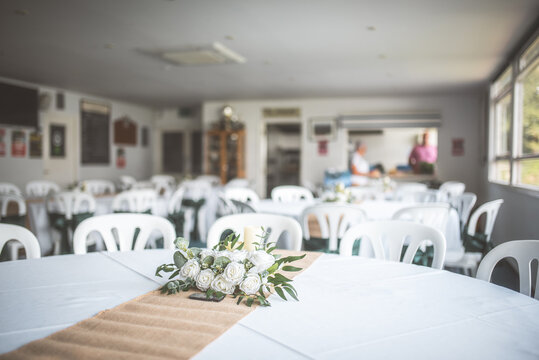 Wedding reception tables decorated with flowers and burlap runner