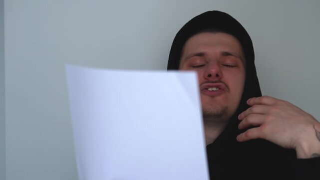 A young actor holding a paper script.
Casting for a role.
An artistic man reads the script in front of the camera.