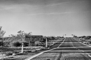 Australian road signs directing to Coral Bay along North West Coastal Highway in Western Australia outback landscape with blue sky