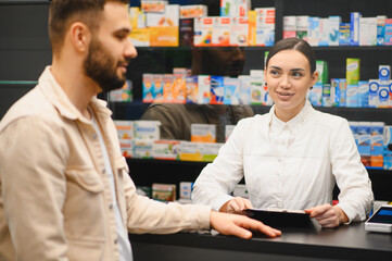 Pharmacist advising customer at pharmacy counter