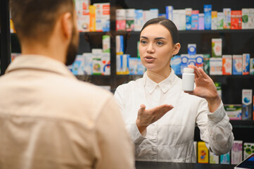 Pharmacist advising customer about medicine in pharmacy