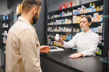 Pharmacist assisting customer buying medicine at drugstore