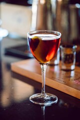 a glass of liquor in a nick and nora glass at a high end bar and restaurant
