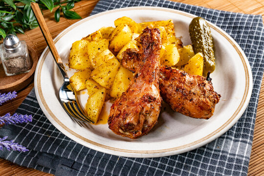 Baked chicken drumsticks with potatoes.