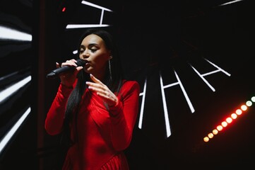 Female singer performing live on stage with microphone