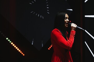 Woman singer performing live on stage with microphone