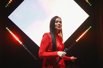 Female singer performing live on stage with microphone
