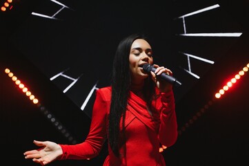 Female singer performing live on stage with microphone