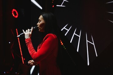 Female singer performing live on stage with microphone