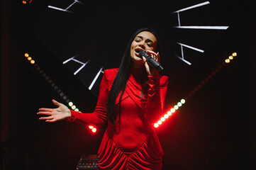 Female singer performing live on stage with microphone
