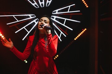 Female singer performing live on stage with microphone