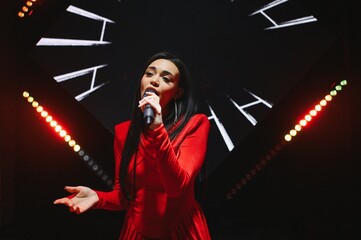 Female singer performing on stage with microphone