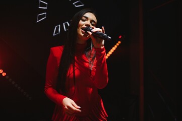 Female singer performing live on stage with microphone
