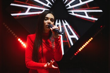 Female singer performing live on stage with microphone